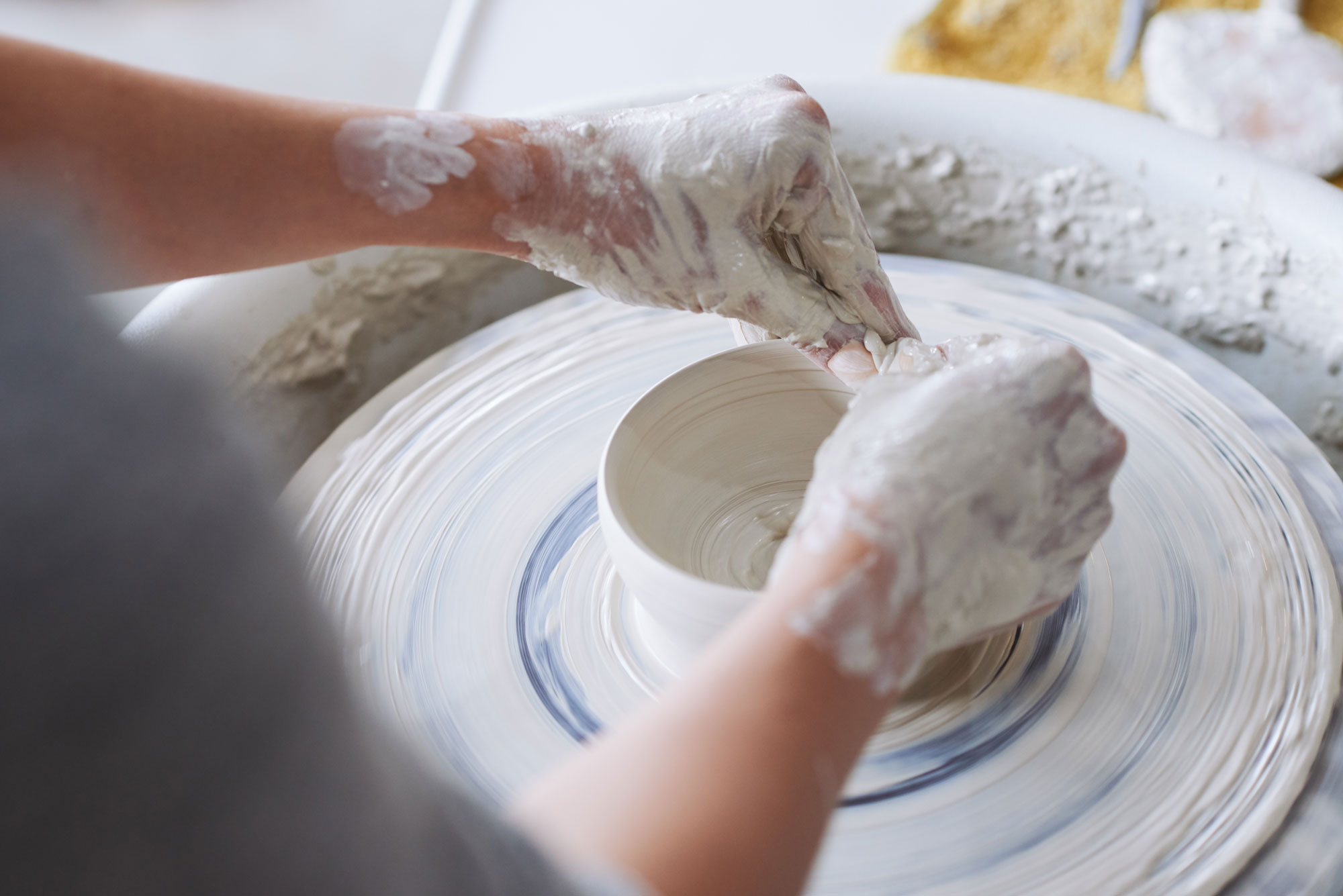 Hands making pottery during a pottery wheel course at LOKI Studio Zurich